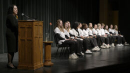 Jami Falk addresses sophomore nursing students on stage.